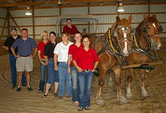 Morrie Waud joins the Morrie Waud Equine Center hospital staff in the facility&rsquo;s covered lameness exam arena.
