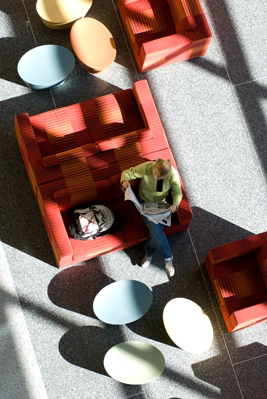 Student relaxing in atrium of new Microbial Sciences building