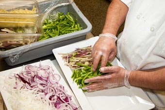 Photo of two serving trays filled with sliced peppers and onions.
