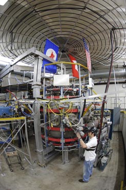 Photo of a grad student performing maintenance work on a large machine.