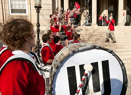 Photo of UW band members playing on the Memorial Union steps, with Mike Leckrone directing.
