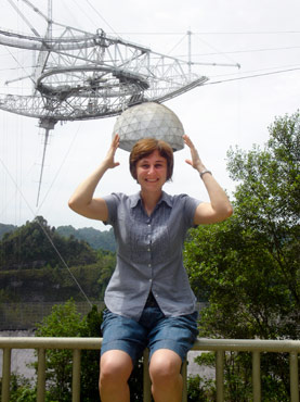 Photo of Snezana Stanimirovic pretending to hold a massive radio telescope at the Arecibo Observatory in Arecibo, Puerto Rico.