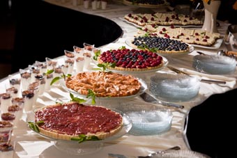 Photo of a table full of fruit-filled tarts and other desserts.