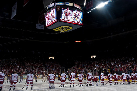 Photo of UW–Madison and Minnesota hockey players pausing for a moment of silence before the game.