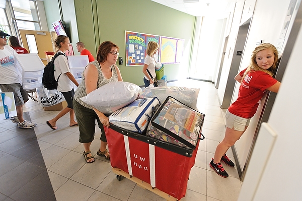 Going up? A Badger Buddy volunteer (right) holds the elevator door as students and family members move belongings into Ogg Residence Hall.
