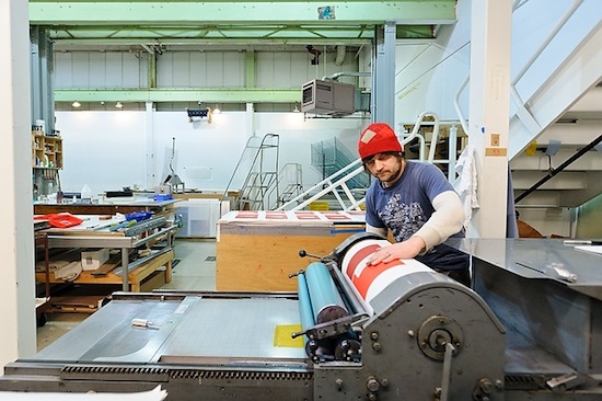 Photo: printmaker at printing press at Tandem Press