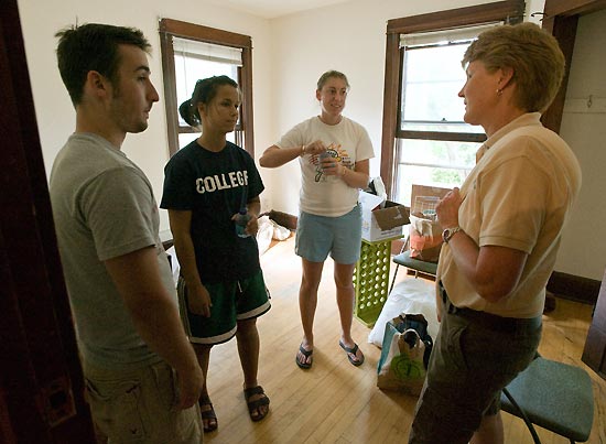 Photo of Dean of Students Lori Berquam meeting with students moving into an apartment