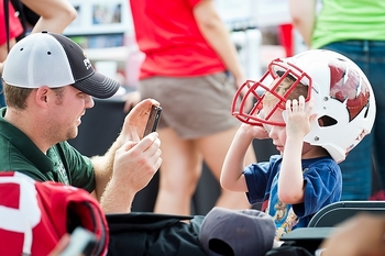 Photo: A father photographs his son as he tries on an iconic W helmet 