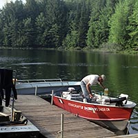 Photo of a student in a boat on Crampton Lake, preparing to go out and drop Carbon -13 into the water.
