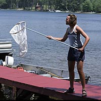 Photo of Alysa Remsburg holding a net, catching dragonflies and damselflies.