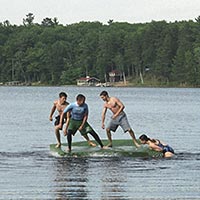 Photo of students playing on a raft at Trout Lake.